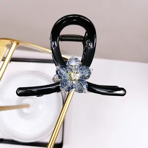 Pince à cheveux noire élégante ornée d'une fleur en cristal bleu et de paillettes