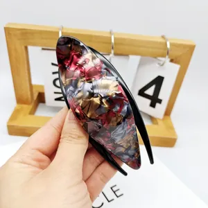 Elegant tortoiseshell acrylic duckbill hair clip with marble texture in a chic hand-held view