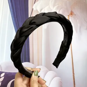 Détail du serre-tête tressé noir avec texture satinée et peigne intérieur antidérapant