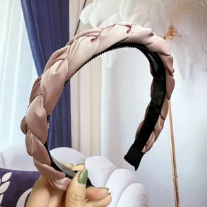 Détail d'un serre-tête tressé rose montrant le tissu satiné et les dents antidérapantes