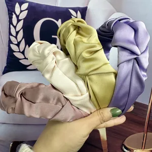 Detail of pleated satin headband set featuring twisted knot design in soft pastel colors