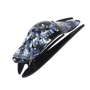 Elegant large hair claw clip with blue marble pattern and sparkling rhinestones