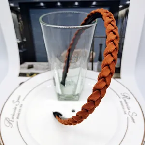 Detailed view of a braided brown headband resting on a white bone china plate