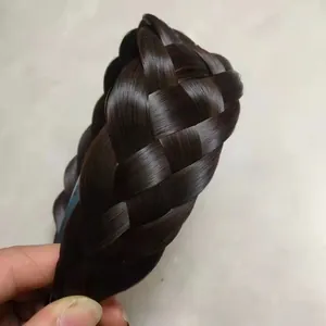 Détail de la texture tressée épaisse en épi de blé sur un serre-tête en cheveux foncés