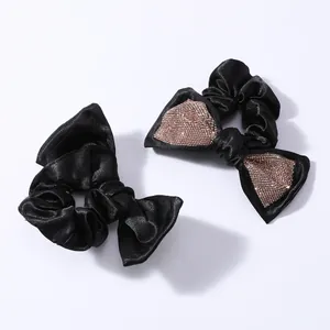 Eleganti elastici per capelli in raso nero con strass e fiocco su sfondo bianco