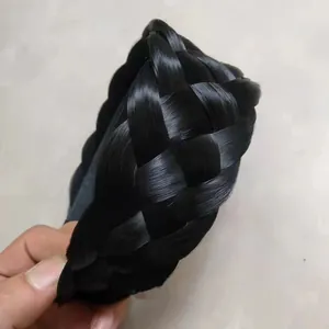 Détail d'un serre-tête tressé noir épais montrant la texture des cheveux et le volume