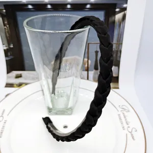 Detail of black braided headband with anti-slip inner teeth on white ceramic plate