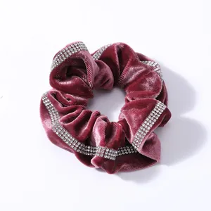 Detalle de un coletero de terciopelo rojo burdeos con adornos de brillantes de imitación