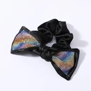 Dettaglio degli strass arcobaleno su un elastico per capelli in raso nero