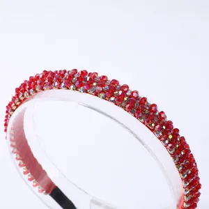 Detalle macro de cuentas de cristal rojo y superficie facetada en una diadema fina