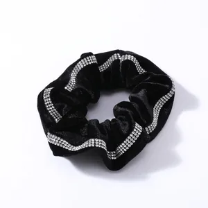 Detalle de coletero de terciopelo negro con brillantes adornos de pedrería ondulada