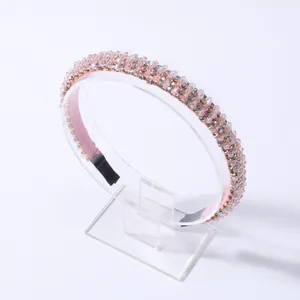 Detalle de diadema rosa con cuentas y cristales brillantes en soporte de exhibición