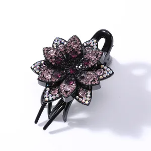 Close-up of black resin flower hair claw clip with purple rhinestones and glossy finish