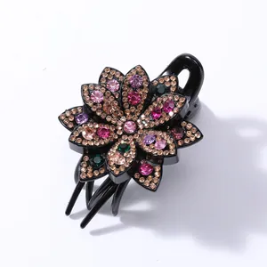 Detailed close-up of a floral hair claw clip featuring colorful inlaid rhinestones