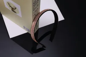 Détail du serre-tête en strass or rose avec doublure antidérapante sur un livre