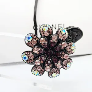 Macro shot of black floral hair claw clip with colorful rhinestones and glossy resin finish