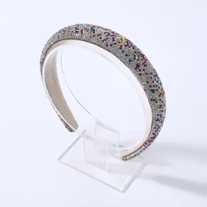 Dettaglio di un cerchietto imbottito con strass colorati e fodera in velluto beige chiaro