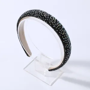 Dettaglio di cerchietto largo in spugna con strass AB iridescenti su supporto bianco