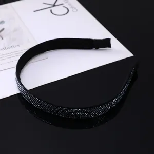 Serre-tête fin noir avec strass bleu foncé sur une surface réfléchissante élégante