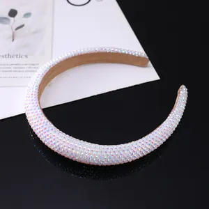 Sparkling crystal padded headband with colorful rhinestones on a glossy black surface