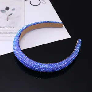 Close-up of blue rhinestones and beige velvet lining on padded fashion headband