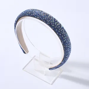 Dettaglio del cerchietto imbottito con strass blu e cristalli su sfondo bianco pulito