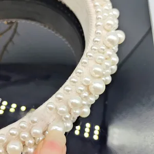 Macro detail of elegant baroque sponge headband featuring layered white faux pearls