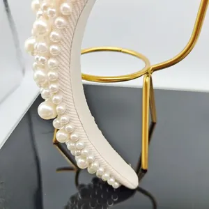 Detail showing high-top Baroque headband with faux pearls and twill fabric texture