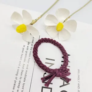 Detailansicht eines lila handgeflochtenen Haargummis mit elegantem Knotendesign