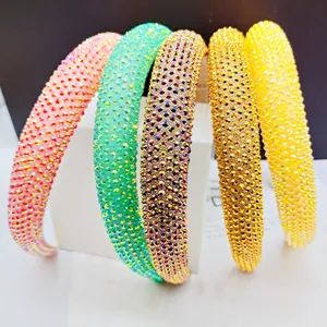 Detail of five colorful sparkling rhinestone padded headbands arranged on display