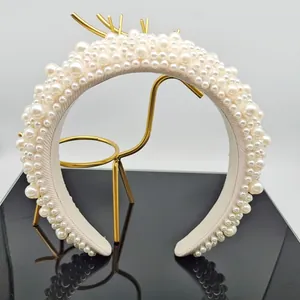 Detailed shot of a thick Baroque white pearl headband on a golden deer stand display