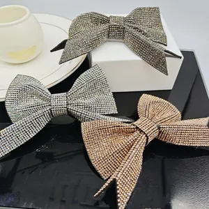 Detailed close-up showing three sparkling rhinestone bow hair clips in silver, gray, and gold