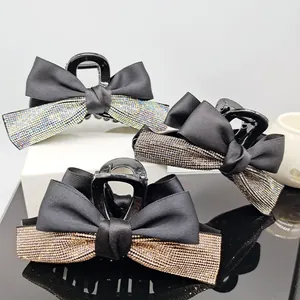 Detail showing elegant ribbon hair claws with sparkling rhinestones in three colors