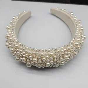 Detailed top view of wide baroque cream headband with studded imitation pearls