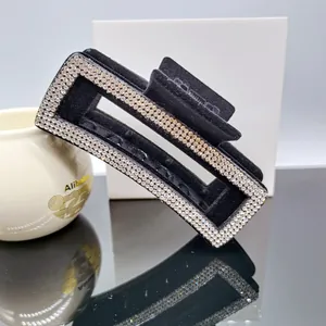 Détail d'une pince à cheveux rectangulaire floquée noire avec trois rangées de strass brillants
