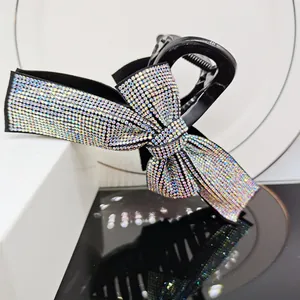 Sparkling bow hair claw clip with multicolored rhinestones and elegant black glossy finish