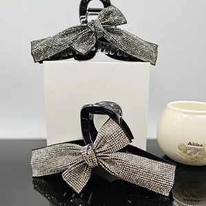 Bow hair claw with rhinestones and ribbon design in black and silver colors