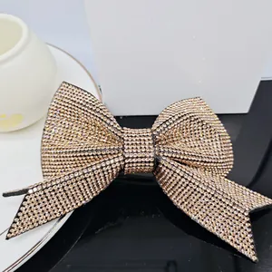 Detailed close-up of champagne gold rhinestone bow hair clip with sparkling crystals