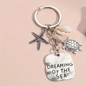 Ocean themed keychain with starfish, turtle and shell pendants on soft pink background