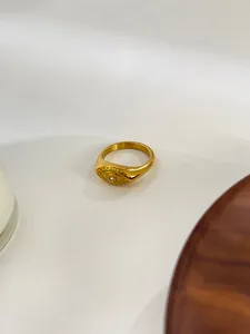Detailed close-up of golden stainless steel evil eye ring with zircon inlay