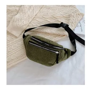 Detailed texture of olive green corduroy waist bag with dual silver zippers and strap