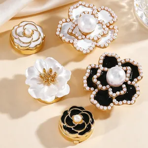 Detalle de gemelos de flores de lujo con perlas y acabado esmaltado