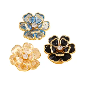 Vista detallada de gemelos de cobre con diseño floral en azul, negro y oro champán.