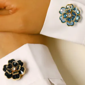 Primer plano de elegantes gemelos florali en azul y negro en puños de camisa blanca