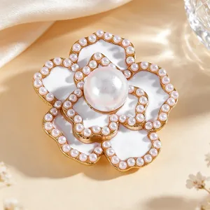 Detalle de gemelo en forma de flor con pétalos de esmalte blanco y detalles de perla