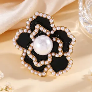 Primer plano de gemelo de flor en esmalte negro decorado con bordes de perlas finas