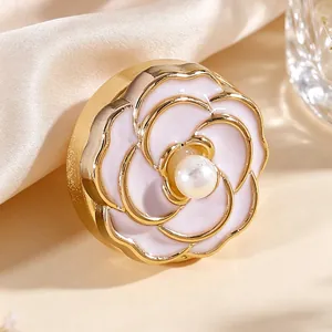 Vista detallada de un gemelo de flor de esmalte blanco con perla sobre seda suave