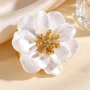 Detalle macro de gemelos de flor con pétalos blancos multicapa y acabado de esmalte dorado.