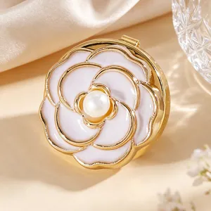 Detalle macro de un gemelo de flor de camelia en esmalte blanco con perla central dorada