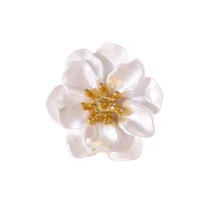 Primer plano detallado del gemelo de flor de esmalte blanco con pistilo dorado en el centro